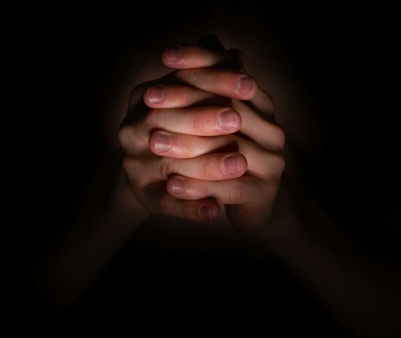 a person holding their hands together in the dark